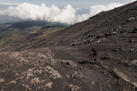 ION Scrub LS long-sleeve cycling jersey in dark charcoal during mountain biking on a volcanic trail