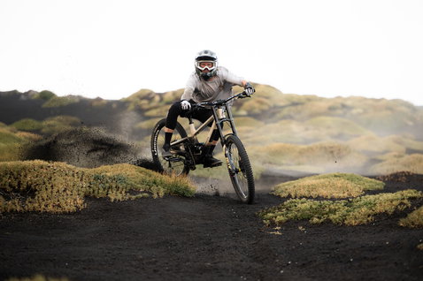 ION Bike Ionic SS Merino short-sleeve jersey in warm grey during mountain biking on a volcanic trail