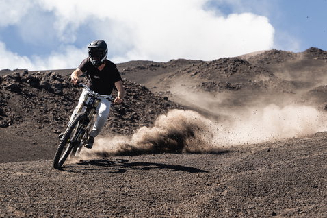 ION Ionic SS DR Lyocell short-sleeve cycling jersey in black during mountain biking on volcanic trail