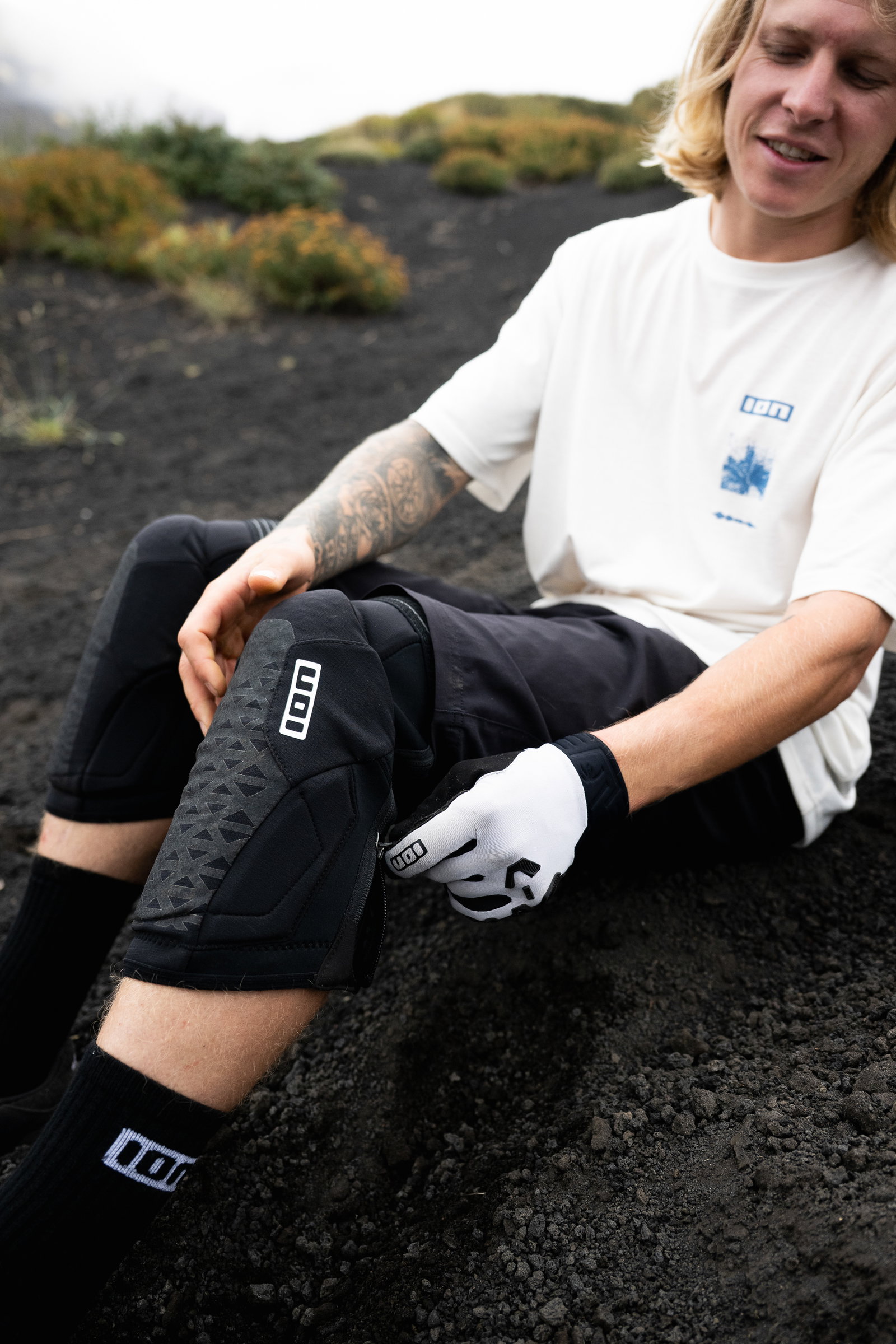 ION K-Pact Zip knee pads in black being put on at a mountain trail