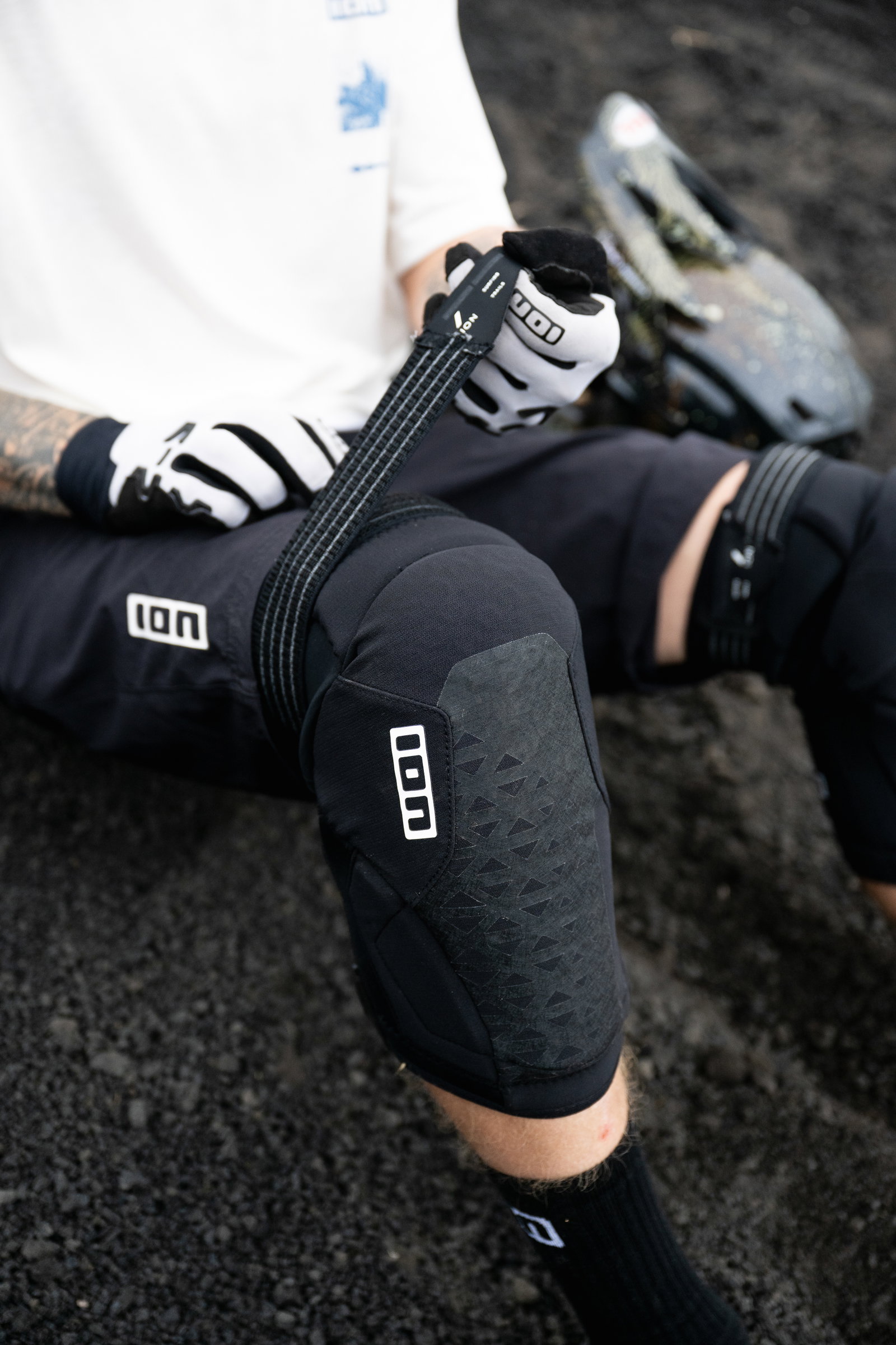 ION K-Pact Zip knee pads in black during mountain biking on a rocky trail