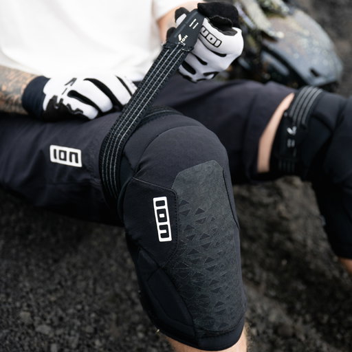 ION K-Pact Zip knee pads in black during mountain biking on a rocky trail