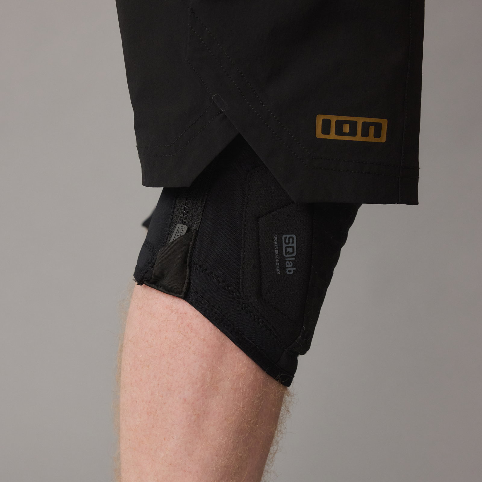 ION K-Pact Zip SQlab knee pads in black, side on-model view showing E-zipper closure