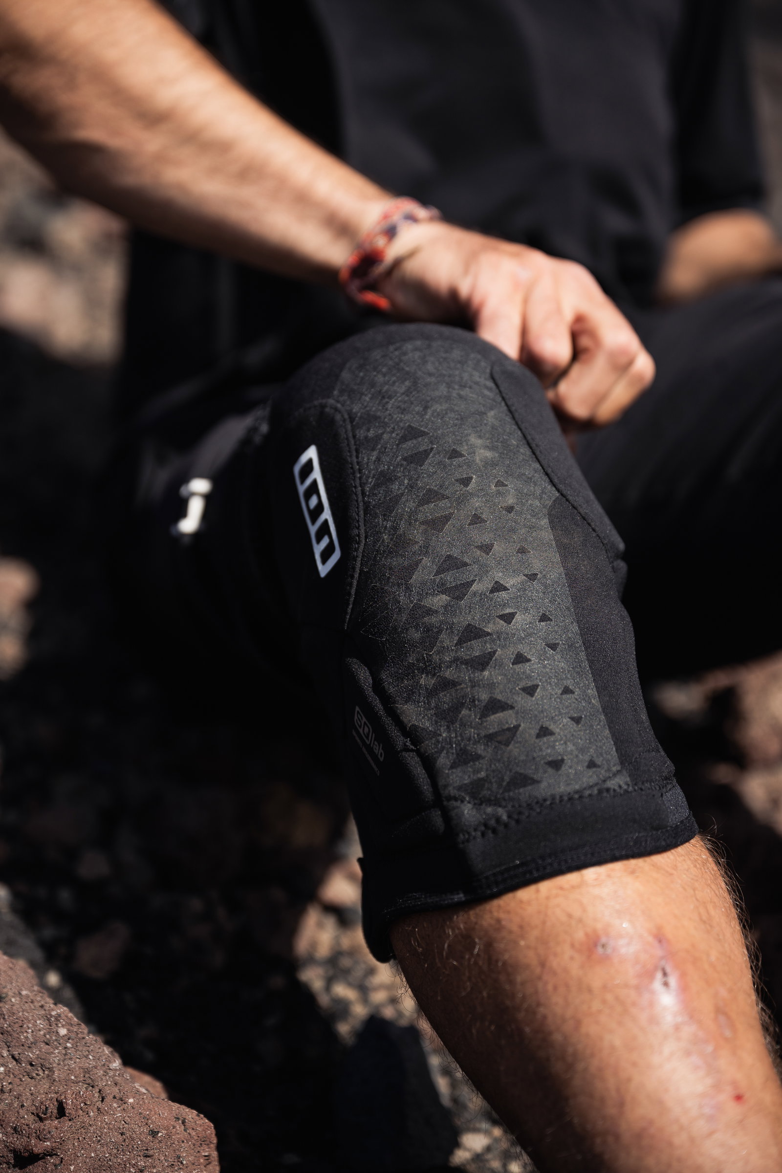 ION K-Pact knee pads in black during mountain biking on rocky terrain
