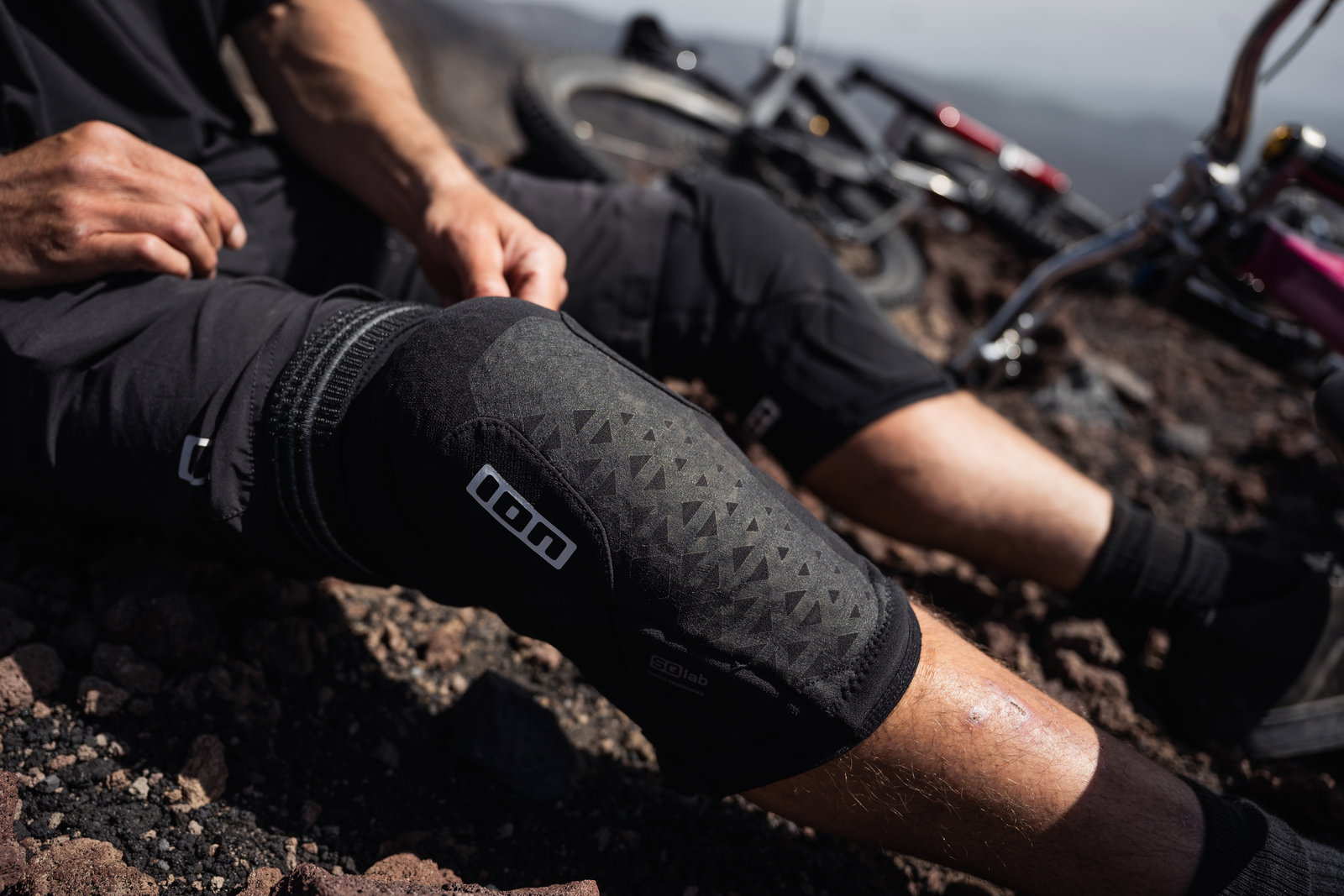 ION K-Pact knee pads in black during mountain biking on a rocky trail