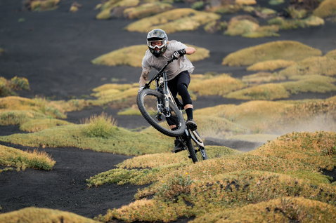 Genouillères ION Bike ARCON Lite unisex en noir lors d'une session de vélo de montagne en terrain volcanique