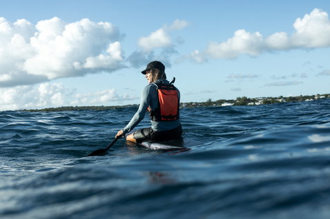 ION Explorer Bag downwind backpack in red-orange during SUP paddling on the ocean
