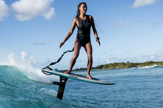 ION Amaze V-Back 1.5mm neoprene swimsuit during prone foiling on tropical ocean in dark navy