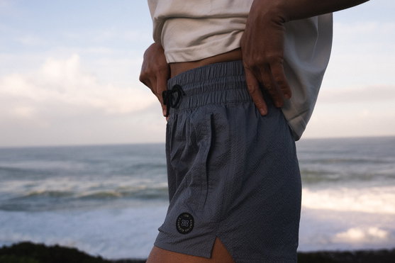 Boardshorts ION Tally 2,5" donna in grigio ardesia indossati sulla costa