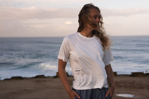 ION Vibes women's short-sleeve tee in white worn at the ocean coast