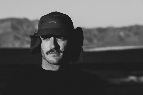 ION Surf Cap PRO surf cap with neck flap during kitesurfing at the coast in black