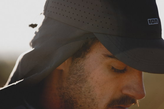 ION Surf Cap PRO surf cap in black with ventilation holes, detail close-up on model