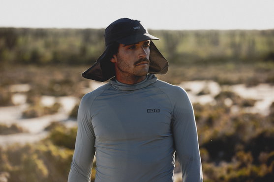 ION Surf Cap PRO in blue nights with neck flap worn at the coast