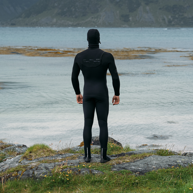 ION Seek Amp 6/5mm hooded front-zip fullsuit in black at a fjord coastline