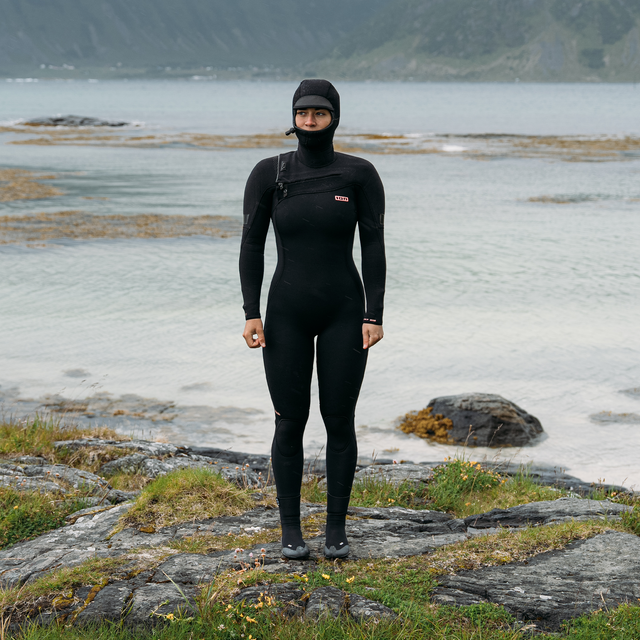 ION Amaze Amp 6/5mm hooded front-zip fullsuit wetsuit in black during surfing at the coast