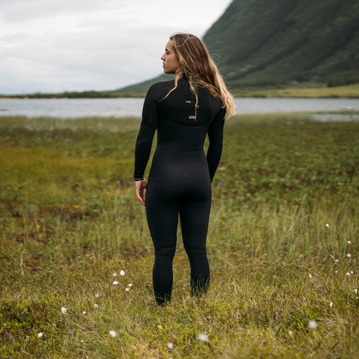 ION Amaze Amp 5/4mm front-zip women's fullsuit wetsuit in black at a coastal location