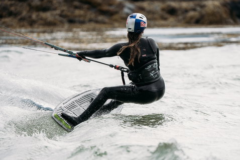 ION Amaze Amp 5/4mm front-zip women's fullsuit in black during kitesurfing in cold water