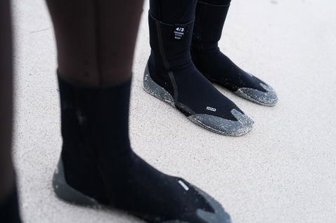 ION Feelgood neoprene socks 4/3mm in black during wave riding at the beach