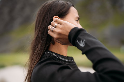 ION Surf Shield long sleeve rashguard unisex in black worn at a rocky coastal location