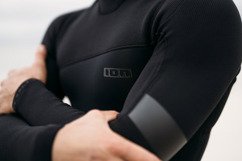 ION Seek Amp 6/5mm back-zip fullsuit in black during surfing at the coast