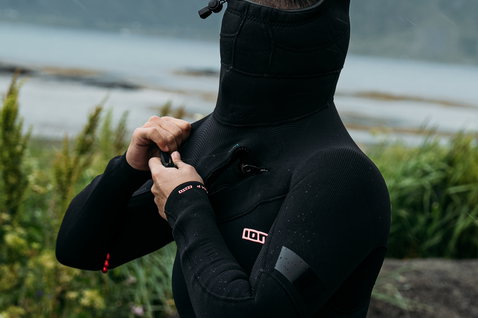 ION Amaze Amp 6/5mm front-zip hooded fullsuit women in black during watersports at the coast