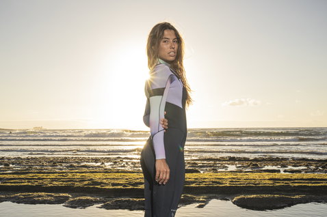 ION Amaze Core 3/2mm Frontzip Damen-Neoprenanzug in schwarz, lavendel und mint beim Tragen am Meer