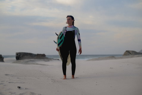 Fato de neoprene ION Amaze Core 4/3mm front-zip feminino em preto, menta e rosa durante o surf na praia
