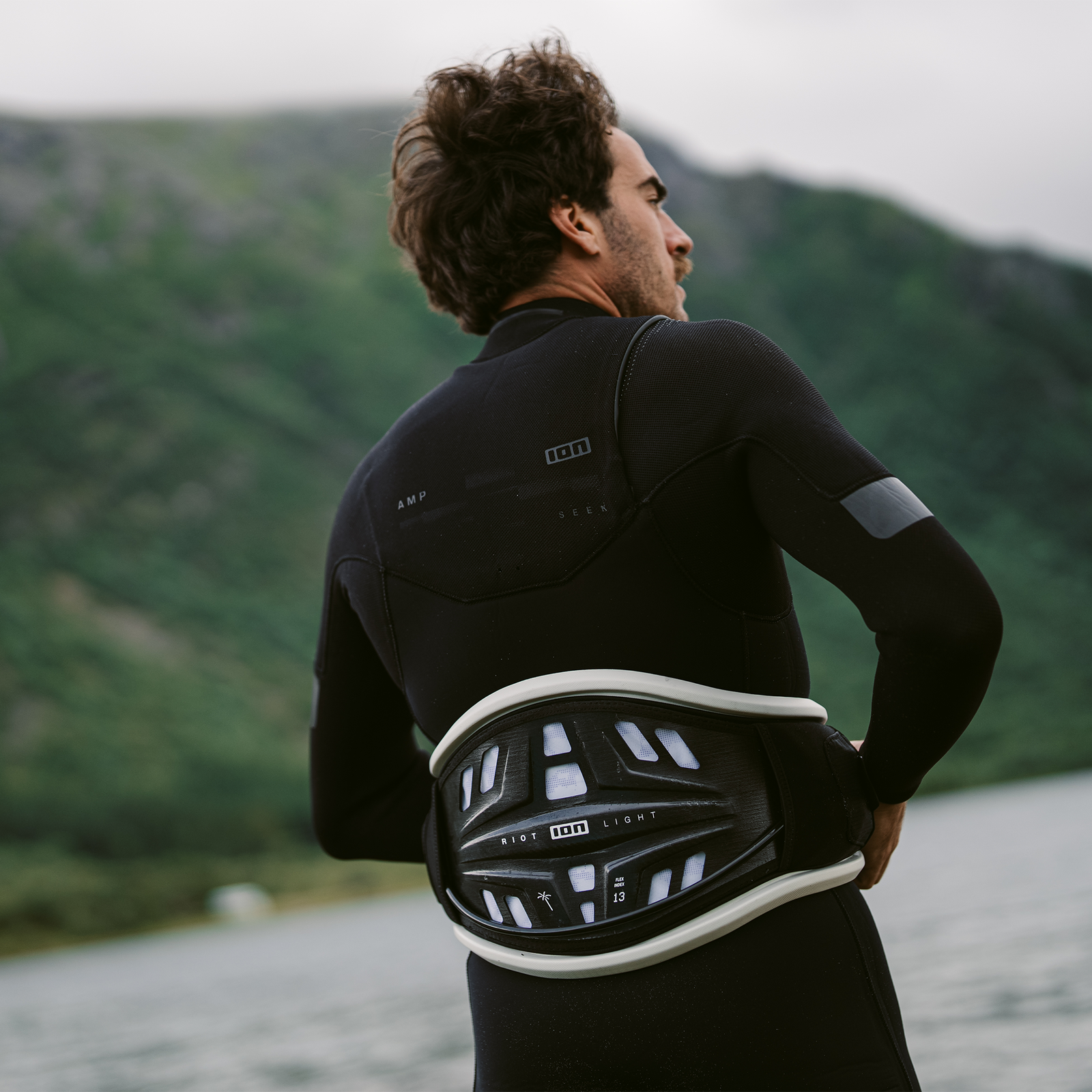 ION Riot Light waist harness in black and white with CURV® hard shell back plate, worn at fjord