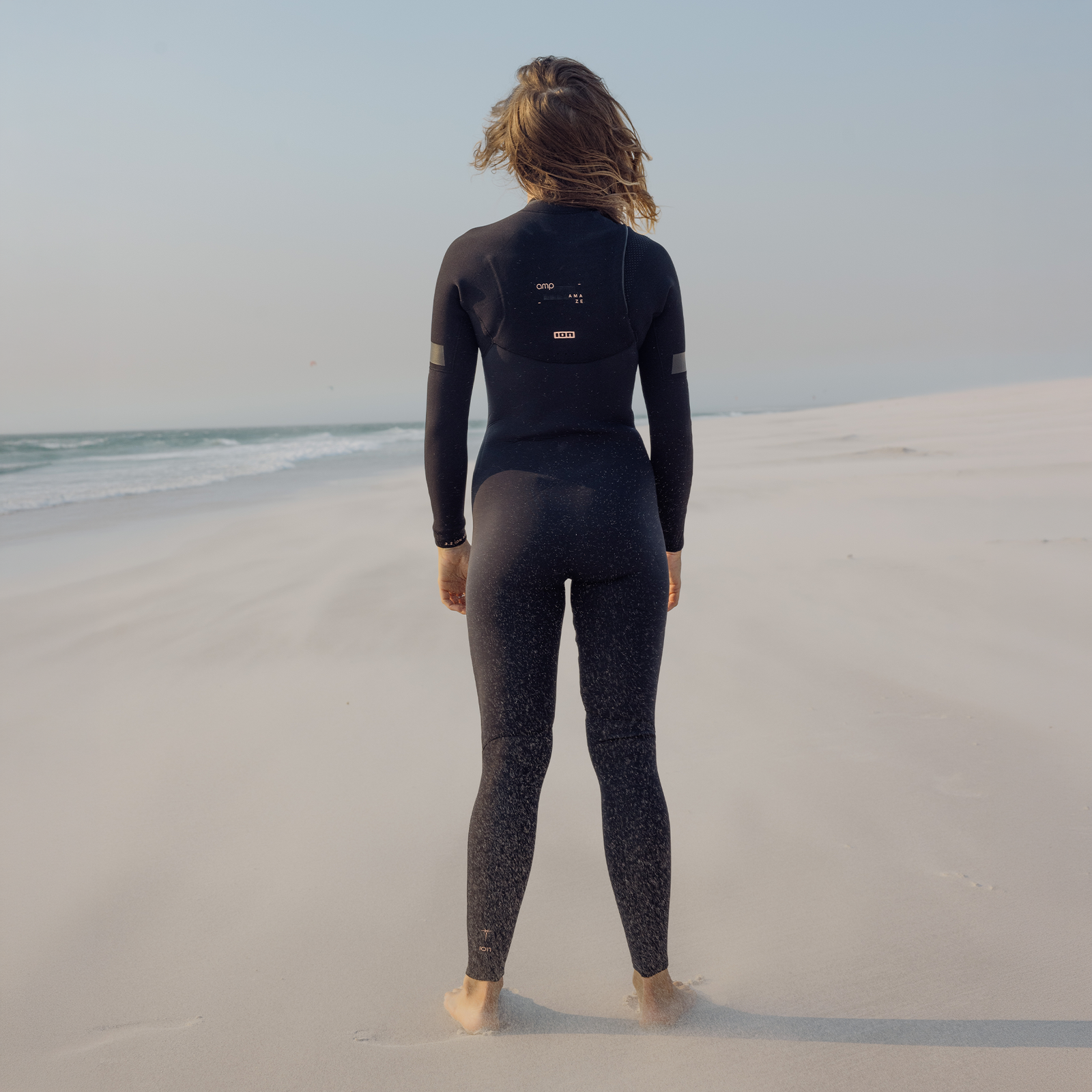 ION Amaze Amp 3/2mm front-zip women's fullsuit in black at the beach