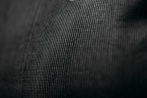 Rashguard manches longues ION Surf Shield unisexe en noir – détail du tissu résistant aux coupures avec logo ION