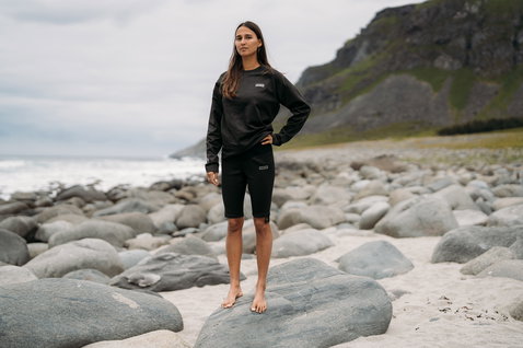 ION Surf Shield wetshirt de manga comprida em preto carvão usado em costa rochosa