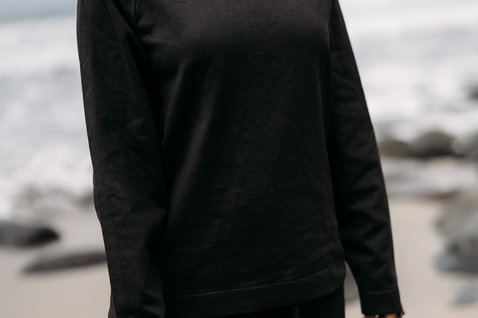 ION Surf Shield wetshirt manga comprida unissex em preto na praia
