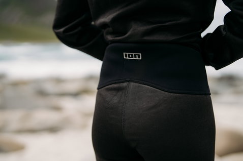 ION Bottom Tights Short Surf Shield unisex during wave riding at rocky coastline in black